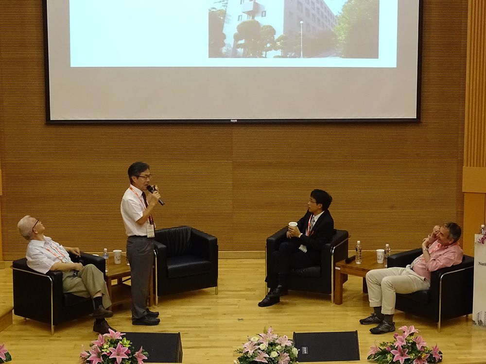 NCTS Mathematics Division Director Jungkai Alfred Chen (陳榮凱; standing) on a panel with scholars, discussing the development of research centers in Taiwan and abroad