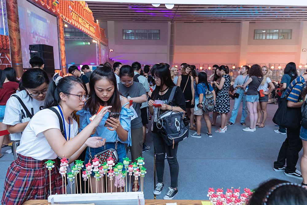 Students line up for doll figurines of Palm Boy and Azalea Girl (NTU mascots).