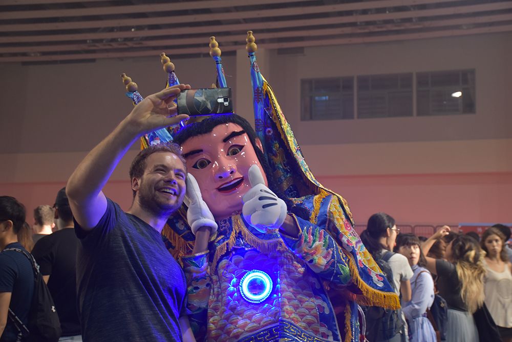 A student takes a selfie with an Electric-Techno Neon God.