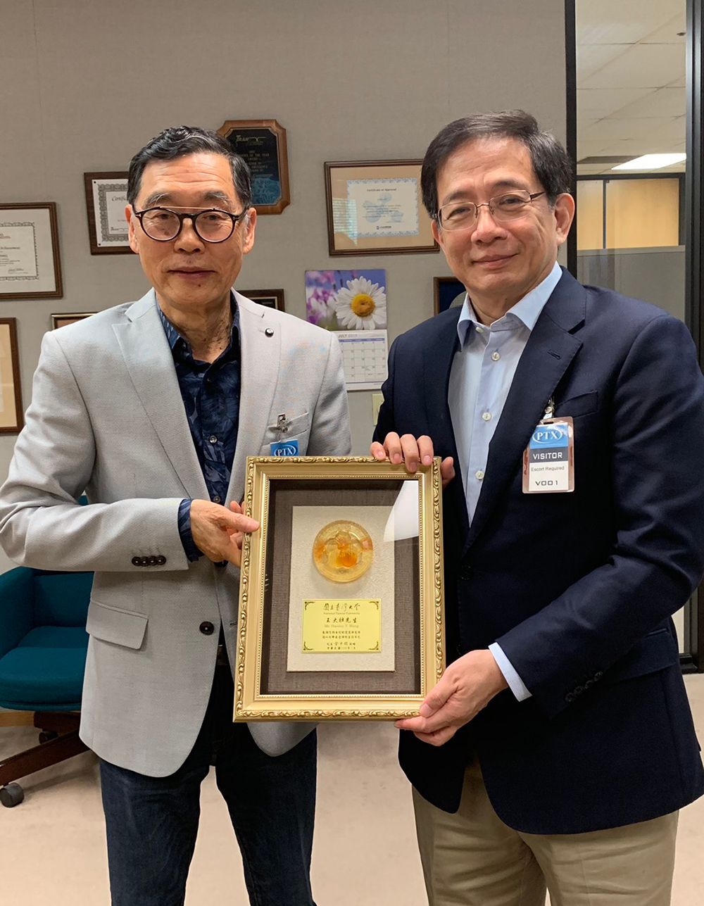 President Kuan (right) presents an appreciation plaque to alumnus Stanley Wang (left).