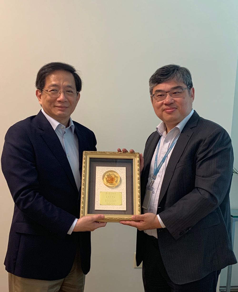 President Kuan (left) presents an appreciation plaque to alumnus Fermi Wang (right).
