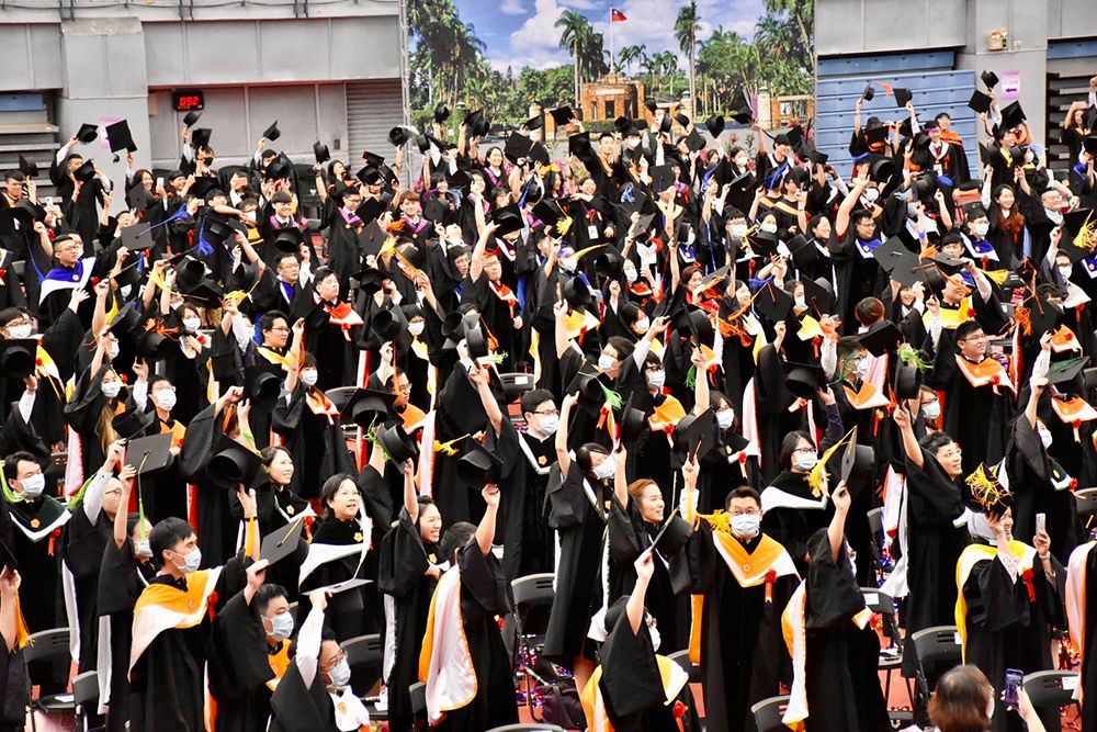 The graduates wave rather than toss their caps for the first time in history to avoid picking up others’ caps and increasing the risk of COVID-19 infection.