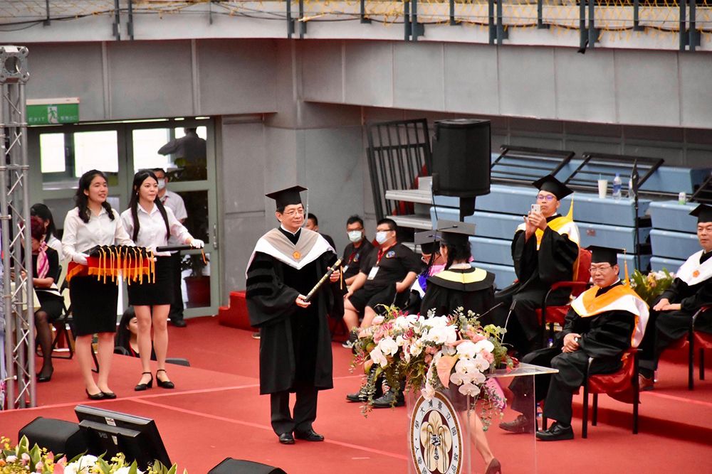 NTU President Kuan hands diplomas to graduate student representatives.