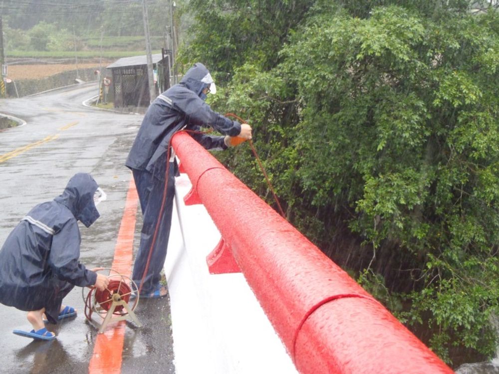 颱風來襲，研究人員日間於颱風雨中採水樣情形。